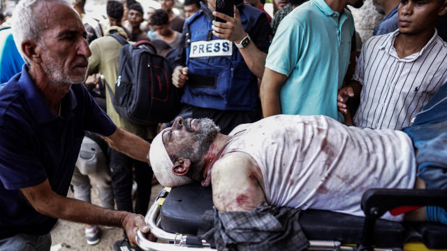 Un homme blessé est transporté sur une civière à l'hôpital des Martyrs d'al-Aqsa à Deir al-Balah, dans le centre de la bande de Gaza, après le bombardement israélien d'un appartement résidentiel à Deir al-Balah et d'une zone d'al-Maghazi, le 8 juin 2024, dans le cadre du conflit actuel entre Israël et le groupe militant palestinien Hamas.