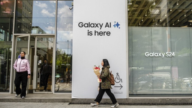 Des piétons marchent devant un magasin Samsung avec des panneaux indiquant "Galaxy AI is here" à Séoul.