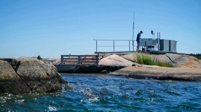 Un chercheur vérifie les instruments d'une station expérimentale sur une petite île faisant partie de la Tvarminne Zoological Station (TZS), la plus grande station de recherche marine de la mer Baltique, à Hanko, Finlande, le 26 juin 2024. 