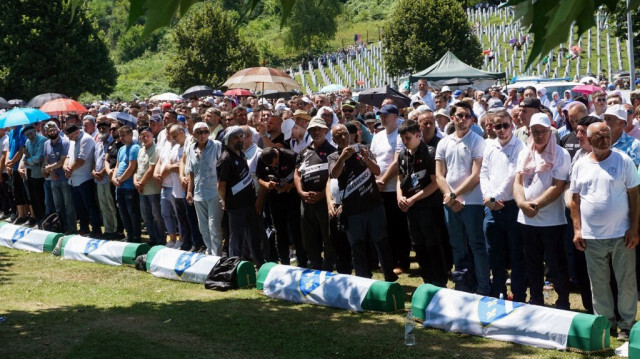 Des musulmans bosniaques prient devant les cercueils des victimes du génocide de Srebrenica en 1995 au cimetière commémoratif du village de Potocari, près de la ville de Srebrenica en Bosnie orientale, à l'occasion du 29e anniversaire du génocide de Srebrenica en 1995, le 11 juillet 2024. 