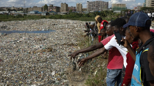 Un homme désigne un corps au bord d'une décharge où six corps ont été découverts à Mukuru, un bidonville de Nairobi, le 12 juillet 2024. 