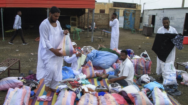 Des personnes déplacées reçoivent des vêtements fournis par une initiative caritative dans un camp de déplacés de la ville de Gedaref, dans l'est du Soudan déchiré par la guerre, le 13 juillet 2024.