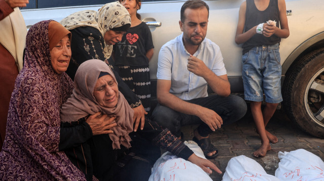 Des femmes palestiniennes pleurant les corps enveloppés de trois enfants tués lors d'un bombardement israélien à Deir el-Balah dans le centre de la bande de Gaza, devant l'hôpital des Martyrs d'al-Aqsa, le 13 juillet 2024. Mohamed Ali al-Rai et ses trois filles, âgées de cinq à neuf ans, ont été tués lors d'un bombardement israélien sur leur maison à Deir el-Balah, a déclaré le Croissant-Rouge palestinien le 13 juillet.