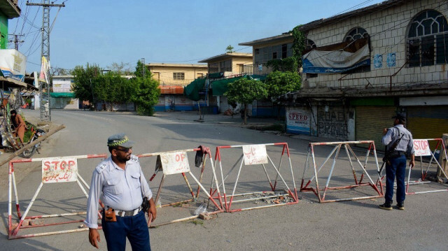 Des policiers montent la garde le long d'une rue barricadée près d'un cantonnement de l'armée, un jour après qu'il ait été attaqué par un groupe de militants suicidaires à Bannu, le 16 juillet 2024.