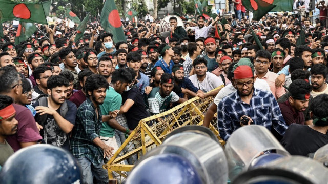 Des étudiants activistes poussent des barricades de police lors d'un rassemblement de protestation avant de soumettre leur mémorandum au président du pays sur les réformes des quotas pour les emplois de la fonction publique, à Dhaka le 14 juillet 2024.