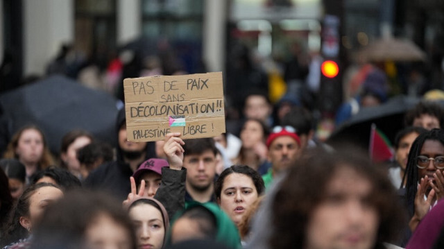 Un manifestant tient une pancarte lors d'un rassemblement contre les attaques israéliennes sur Rafah, dans le centre de Paris, en France, le 29 mai 2024.