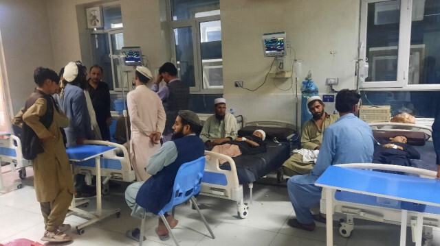 Des hommes sont assis à côté d'enfants blessés alors qu'ils reçoivent des soins dans un hôpital après une tempête et de fortes pluies à Jalalabad le 15 juillet 2024.