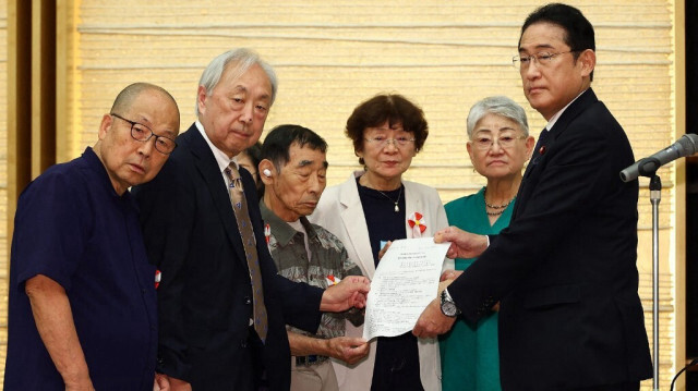 Le Premier ministre japonais Fumio Kishida (D) reçoit une lettre de demande de la part des plaignants dans le procès de stérilisation forcée au bureau du Premier ministre à Tokyo, le 17 juillet 2024.