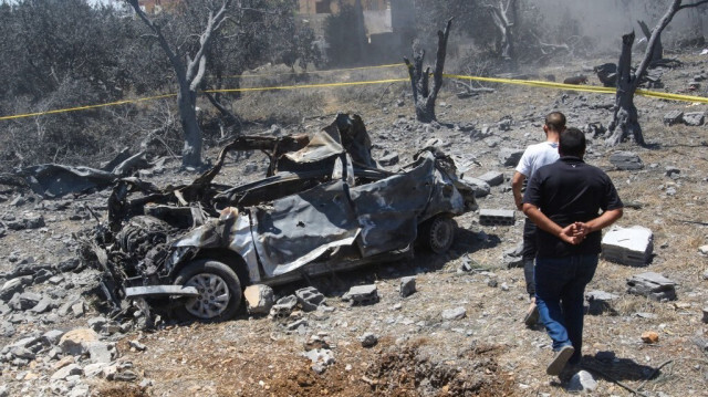 Un véhicule détruit parmi les débris après une frappe aérienne israélienne près du village libanais de Jmaijmeh, le 19 juillet 2024.