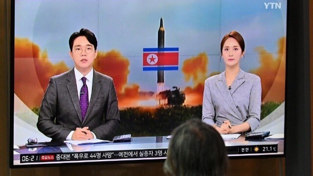 Un homme regarde un écran de télévision diffusant un bulletin d'information avec des images d'archives d'un essai de missile nord-coréen, dans une gare de Séoul, le 19 juillet 2023.