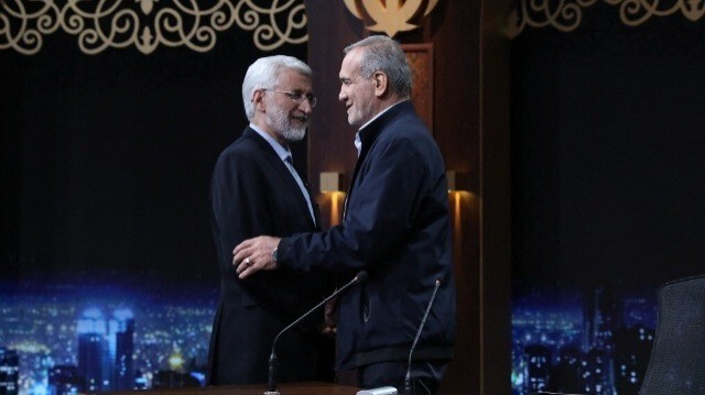 L'ancien négociateur nucléaire ultraconservateur, Saeed Jalili (G) et le candidat réformateur, Massoud Pezeshkian (D) se saluant après avoir participé à un débat électoral télévisé dans le studio de la télévision d'État iranienne à Téhéran, le 1er juillet 2024.