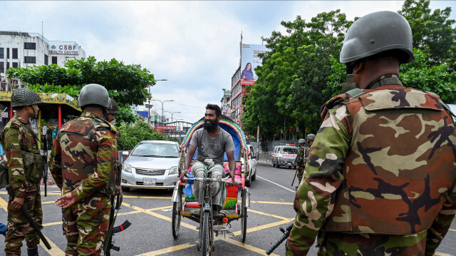 Le 20 juillet 2024, des soldats bangladais montant la garde à la suite d'un couvre-feu et du déploiement de forces militaires à Dacca, après plusieurs jours d'affrontements lors de manifestations contre les quotas d'emplois dans le gouvernement à travers le pays. Les soldats se sont déployés en force le 20 juillet dans les villes du Bangladesh après une nouvelle journée d'affrontements meurtriers entre les étudiants protestataires et la police, qui a incité le Premier ministre Sheikh Hasina à annuler les visites à l'étranger.