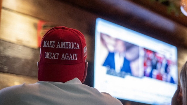 Les gens regardent le discours d'acceptation de Donald Trump dans un bar lors de la dernière nuit de la RNC, le 18 juillet 2024 à Milwaukee, dans le Wisconsin. 