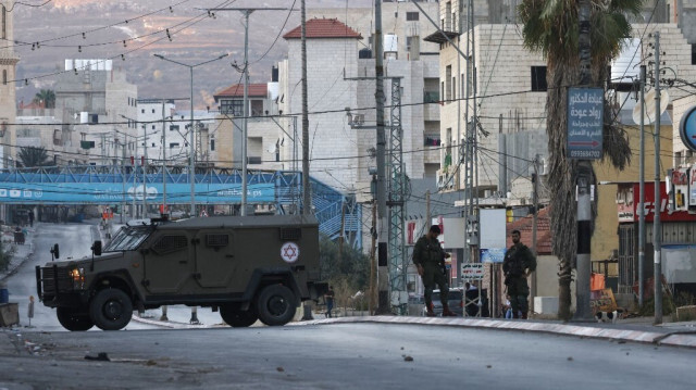 Les colons israéliens ferment l'entrée principale de la ville de Huwara, en Palestine occupée, le 19 juillet 2024.