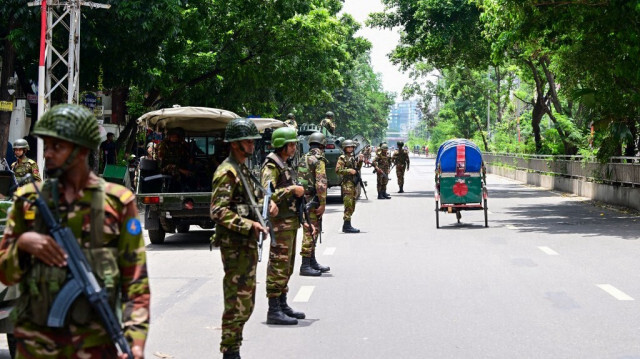 Des soldats bangladais montent la garde le long d'une rue pendant un couvre-feu dans le cadre des manifestations contre les quotas, à Dhaka, le 23 juillet 2024.