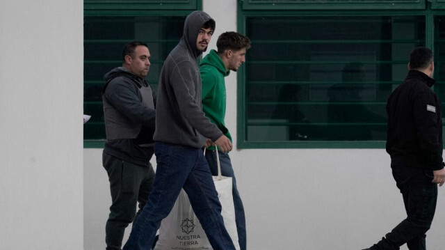 Les joueurs de rugby français Hugo Auradou (2ème à gauche) et Oscar Jegou (3ème à gauche) escortés par des membres du service pénitentiaire de Mendoza, en Argentine, le 17 juillet 2024.