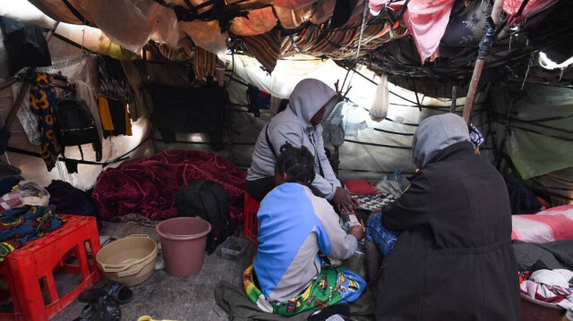 Des migrants d'Afrique subsaharienne se rassemblent à l'intérieur d'une tente dans un camp à Jebeniana, dans le gouvernorat de Sfax, en Tunisie, le 24 avril 2024. 