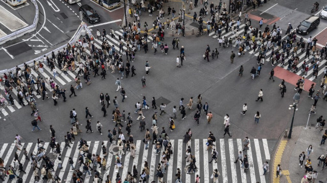 Une foule de personnes traverse la rue à Shibuya Crossing, l'un des carrefours les plus fréquentés au monde, dans le quartier de Shibuya à Tokyo.