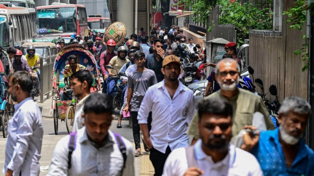 Des personnes circulent sur une route de Dhaka le 24 juillet 2024, après que les autorités ont allégé le couvre-feu imposé pour contenir les affrontements meurtriers déclenchés par les protestations des étudiants sur les quotas d'emploi dans la fonction publique.