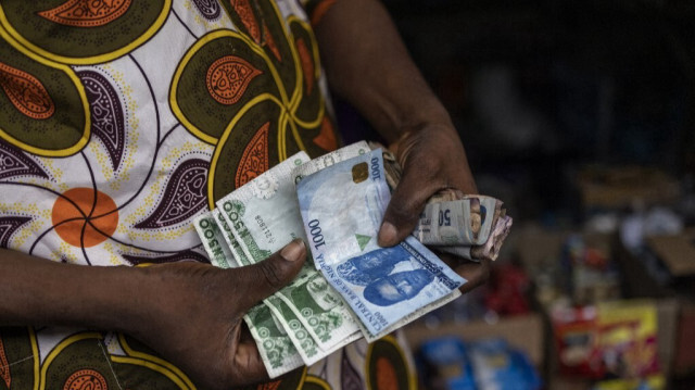 Un vendeur montre d'anciens et de nouveaux billets de banque en naira nigérian sur un marché de Lagos, le 16 février 2023. 