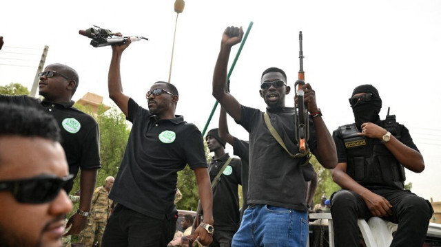 Des hommes armés saluent le gouverneur de l'État soudanais de la mer Rouge, Mustafa Mahmud, à Port-Soudan, dans ce pays déchiré par la guerre, le 24 juillet 2024.