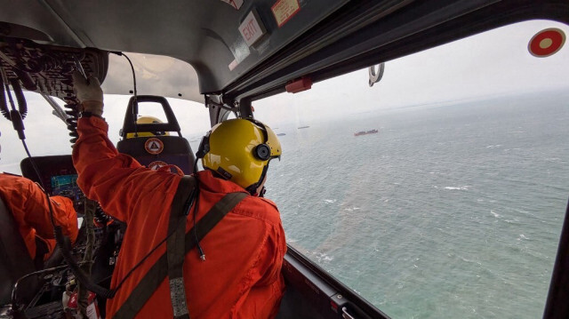 Les gardes-côtes philippins (PCG) montre le personnel des gardes-côtes à bord d'un hélicoptère effectuant une reconnaissance aérienne au large de Manille, après le chavirement du pétrolier MT Terra Nova, le 25 juillet 2024.