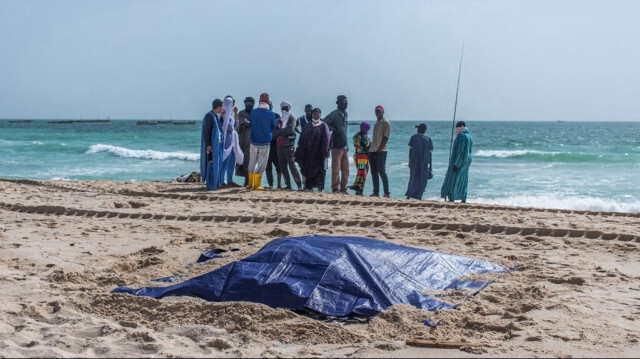 Des badauds regardent les corps recouverts de migrants qui ont péri dans un naufrage au large de la Mauritanie, sur une plage près de Nouakchott, le 24 juillet 2024. 