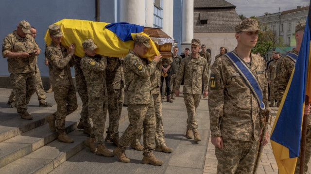 Des soldats ukrainiens portent le cercueil d'un soldat ukrainien tué dans la région de Donetsk, lors de ses funérailles devant le monastère Saint-Michel au dôme d'or à Kiev, le 28 mai 2024.