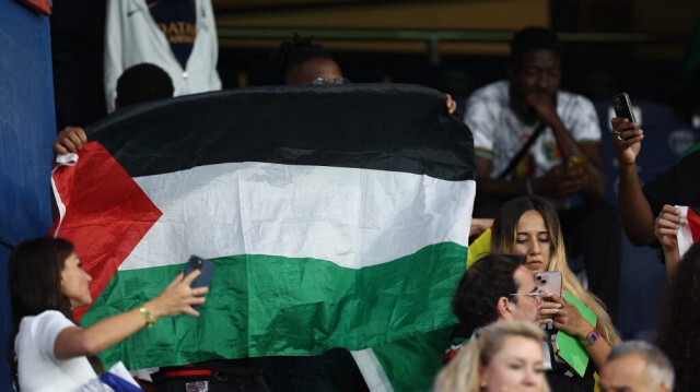 Des supporters brandissent un drapeau palestinien lors du match de football entre le Mali et Israël lors des Jeux Olympiques de Paris 2024 au Parc des Princes à Paris, le 24 juillet 2024.