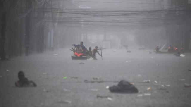 Des sauveteurs pagaient sur leurs bateaux le long d'une rue inondée à Manille le 24 juillet 2024, suite aux fortes pluies provoquées par le typhon Gaemi.