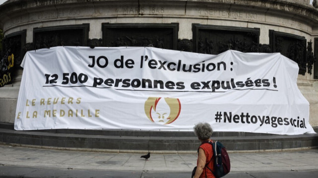 Une banderole lors d'une "contre-cérémonie" organisée par l'Union syndicale Solidaires pour attirer l'attention sur l'impact social des Jeux olympiques, place de la République à Paris, le 25 juillet 2024, un jour avant la cérémonie d'ouverture des Jeux olympiques de Paris 2024.