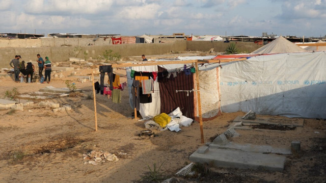 Des Palestiniens déplacés de la partie est de Khan Yunis installent un camp temporaire dans un cimetière de la partie ouest de la ville, dans le sud de la bande de Gaza, le 26 juillet 2024.