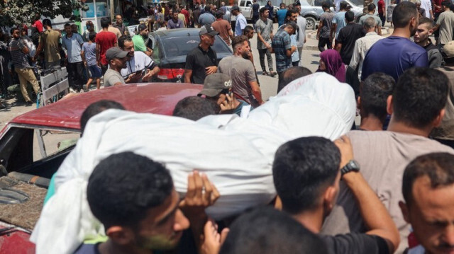 Des Palestiniens portent le corps d'une victime des bombardements israéliens lors d'une procession funéraire devant l'hôpital des martyrs d'Al-Aqsa à Deir el-Balah, dans le centre de la bande de Gaza, le 27 juillet 2024.