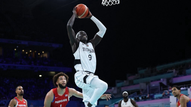 Wenyen Gabriel, du Soudan du Sud, tente un dunk lors du match de groupe C de basket-ball entre le Soudan du Sud et Porto Rico, pendant les JO 2024 de Paris, au stade Pierre-Mauroy de Villeneuve-d'Ascq, le 28 juillet 2024.  