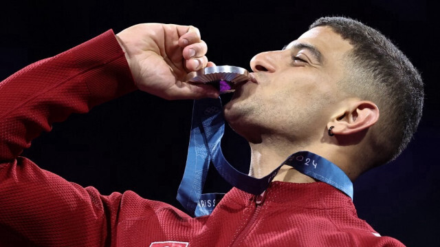 Le médaillé tunisien d'argent, Fares Ferjani, sur le podium lors de la cérémonie de remise des médailles pour la compétition individuelle de sabre masculin aux JO 2024 de Paris, au Grand Palais à Paris, le 27 juillet 2024.  