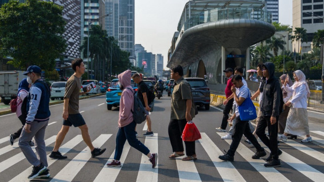 Des piétons traversent une rue à Jakarta en Indonésie.