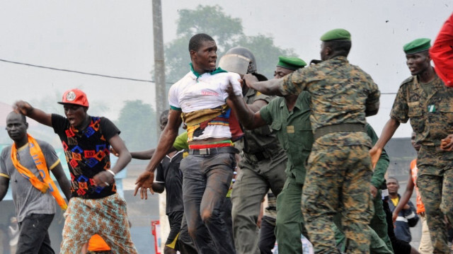 Des policiers guinéens arrêtent des partisans de l'ancien chef de la junte guinéenne en exil, Moussa Dadis Camara, le 26 août 2015, à Conakry.