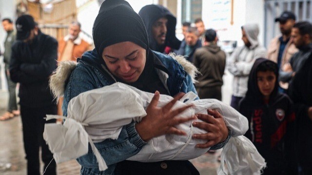 Une femmes palestinienne pleure en portant le corps enseveli d'un enfant palestinien tué à la suite de frappes israéliennes à Rafah, dans le sud de la bande de Gaza, le 6 mai 2024.
