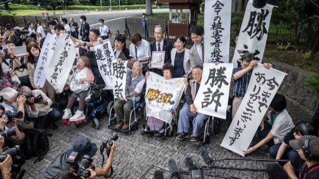 Des victimes de stérilisation forcée en vertu d'une loi eugénique aujourd'hui disparue célèbrent avec des avocats et des sympathisants devant la Cour suprême du Japon, à Tokyo, le 3 juillet 2024.