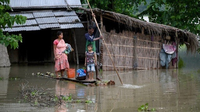 Une famille transporte ses affaires sur un radeau de bananes dans le village de Mayong, touché par les inondations, dans le district de Morigaon en Inde, le 2 juillet 2024.