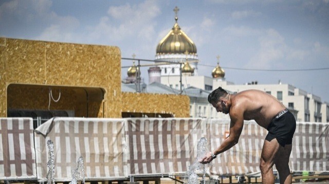 Un homme se rafraîchit dans une fontaine devant la cathédrale du Christ Sauveur au centre de Moscou le 3 juillet 2024. 