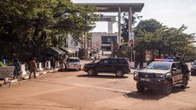 Une voiture de patrouille de la police ougandaise passe devant l'entrée du Parlement avant une manifestation anti-corruption prévue à Kampala le 23 juillet 2024.