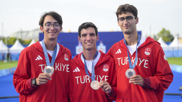 Ulas Berkim Tumer (C), Abdullah Yildirmis (D) et Mete Gazoz (G) de l'équipe de Türkiye obtiennent la médaille de bronze dans l'épreuve de tir à l'arc masculin, au troisième jour des JO 2024 de Paris, le 29 juillet 2024.