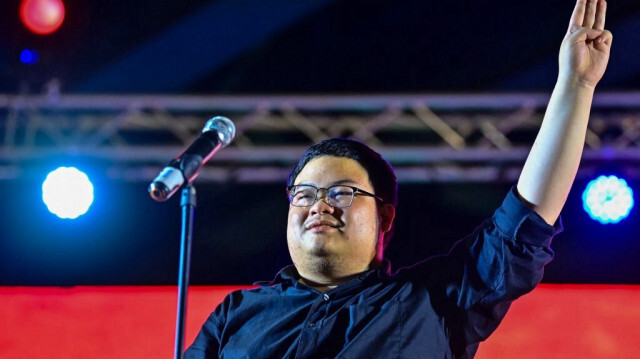 L'activiste Parit "Penguin" Chiwarak fait le salut à trois doigts aux manifestants pro-démocratie lors d'un rassemblement anti-gouvernemental à l'intersection Lat Phrao à Bangkok le 2 décembre 2020.