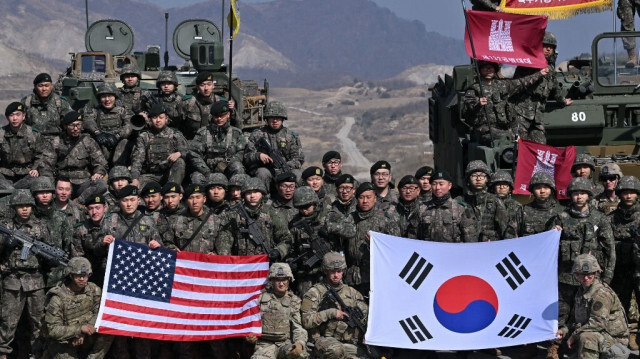 Des soldats sud-coréens et américains posent pour des photos après leur exercice conjoint de tir réel sur un terrain d'entraînement militaire à Pocheon, le 14 mars 2024, dans le cadre de l'exercice militaire conjoint annuel Freedom Shield entre la Corée du Sud et les États-Unis.