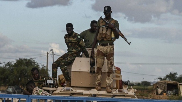 Des militaires nigériens montent la garde alors que des partisans du Conseil national de sauvegarde de la patrie (CNSP) se rassemblent devant la base aérienne nigérienne et française de Niamey, le 3 septembre 2023, alors que des manifestants se rassemblent pour demander le départ de l'armée française du Niger.