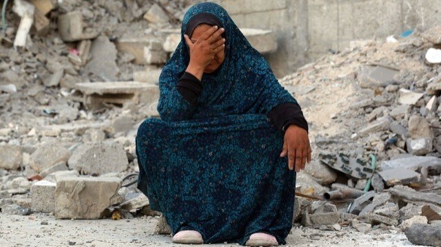 Une femme palestinienne assise au-dessus des débris des précédents bombardements israéliens, à Khan Younès dans le sud de la bande de Gaza, le 4 juillet 2024, alors que la barre des 38 000 morts a été dépassée aujourd'hui.