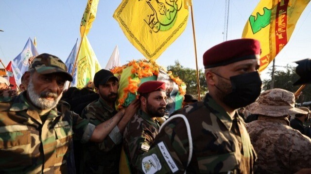Des membres de groupes armés irakiens portent lors des obsèques d'Abu Baqr al-Saadi, un leader éminent des Kataeb Hezbollah, à Bagdad, le 8 février 2024.  