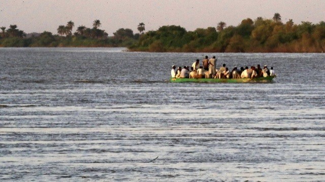 Des personnes empruntent un bac sur les eaux du Nil près de la sixième cataracte, connue sous le nom de chute d'eau "Salbouka" - l'une des zones touristiques les plus importantes du Soudan et la première chute d'eau sur le cours du fleuve après la rencontre du Nil blanc et du Nil bleu dans la capitale Khartoum - à environ 100 kilomètres au nord de Khartoum, le 22 octobre 2022. 