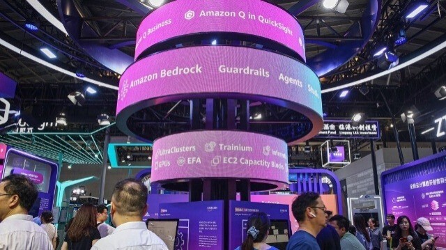 Des visiteurs passent devant un stand d'Amazon lors de la conférence mondiale sur l'intelligence artificielle (WAIC) à Shanghai, le 5 juillet 2024.